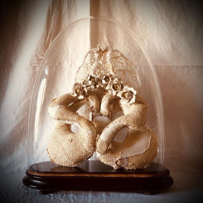Visuel de l'exposition "Corps, mémoire, inconscient", qui représente des organes en broderie, exposés sous une cloche de verre.